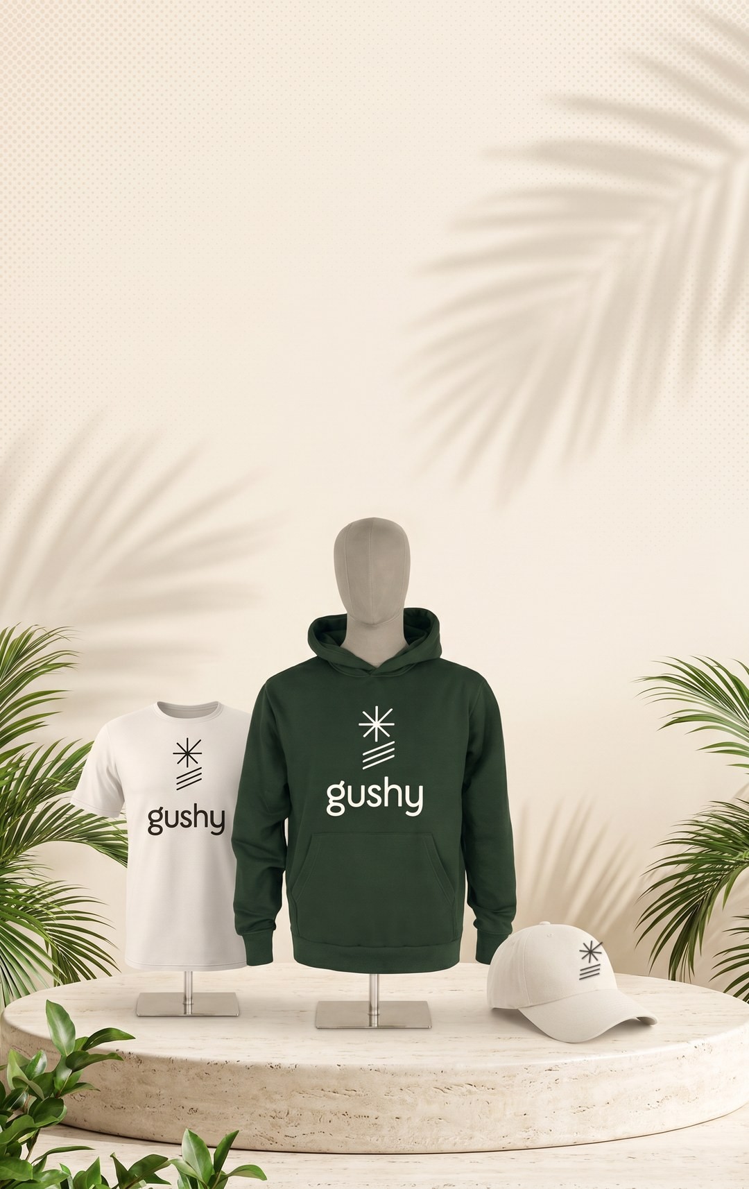 Gushy apparel on a round stone platform, a green hoodie, cream tee and cap