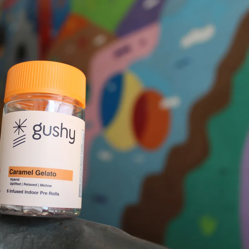 A Caramel Gelato jar in front of a colorful painted mural