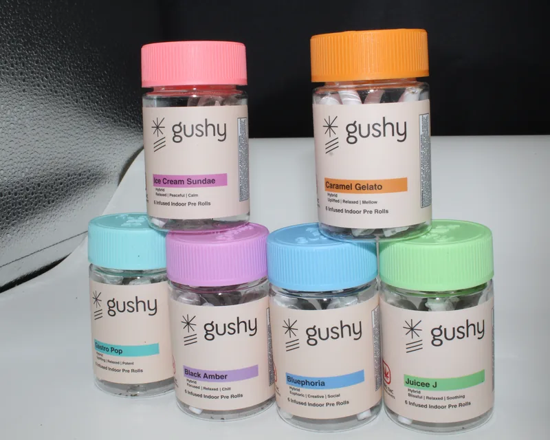 Six Gushy pre-roll jars stacked two over four, every lid a different color